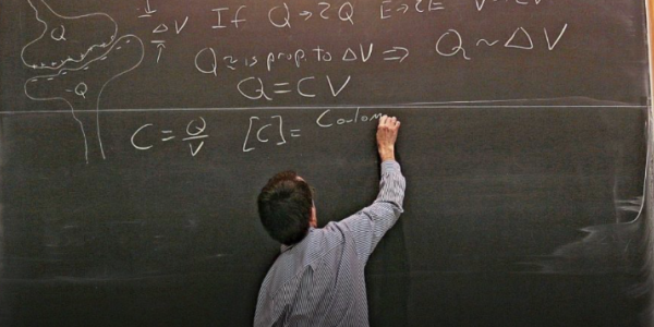 A Nobel laureate teaching first-year physics class in front of a chalk board