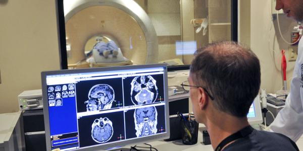 Two people look at a scan of a brain.