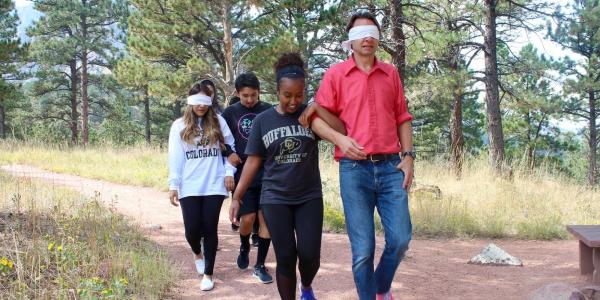 Student leading instructor on blindfolded walk trust building activity