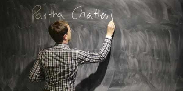 A teacher writing something on a chalkboard