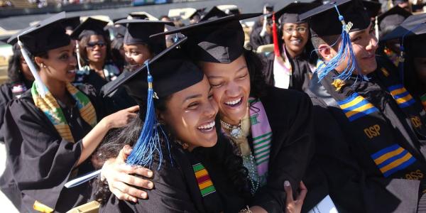Graduating students hugging each other at commencement