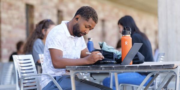 Student on patio on laptop