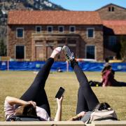 Two students lying in the grass of Farrand Field on the first day of spring